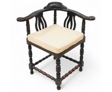 Victorian carved oak corner chair, shaped arms carved with trailing leafy branches, pierced splats over panelled seat, on bob