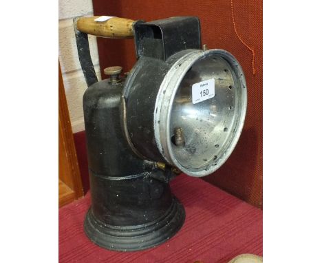 A painted metal carbide hand lamp with turned wooden handle, 32cm high.