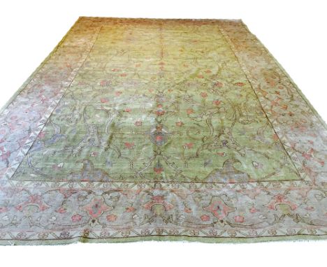 FINE OUSHAK CARPET, 515cm x 340cm, garous design of palmettes and scrolling vines on a light jade field within complimentary 