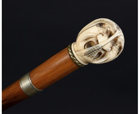 JAPANESE IVORY TOP WALKING STICK Meiji period, the ivory handle carved in the form of an expressive male face, supported on a