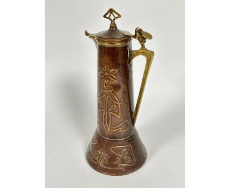 A late 19thc Art Nouveau copper and brass mounted ewer of tapered cylinder form with domed top and brass shaped finial and br