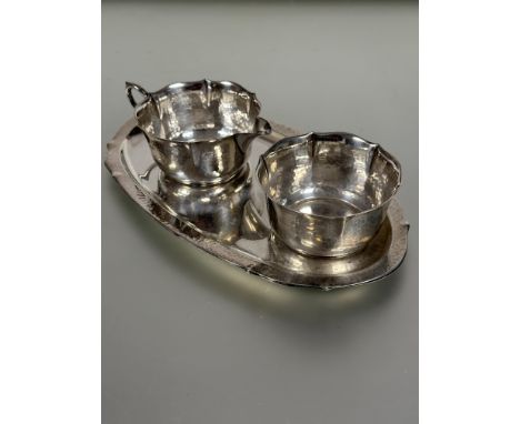 A early 20thc German WMF 835 standard white metal oval tray with milk jug and sugar basin of lotus shape with planished finis