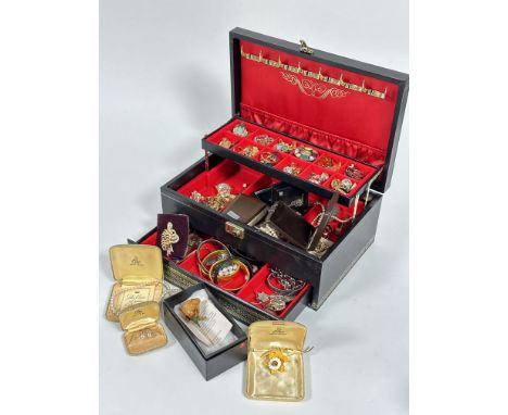 A black jewellery box containing a large collection of paste, gilt metal and ceramic clip on earrings, paste brooches, gilt m