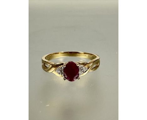 A 9ct gold ruby and diamond ring set oval ruby approximately 0.02ct in four claw setting flanked by three diamonds to each sh