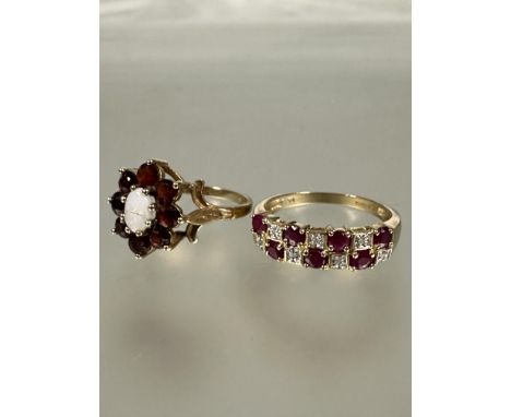 A 9ct gold seven stone ruby and diamond set alternating ring, P and a 9ct gold opal and garnet cluster ring, the oval opal a/