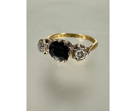 A 8ct gold and platinum set three stone sapphire and diamond ring, the circular sapphire approximately 0.75ct flanked by old 