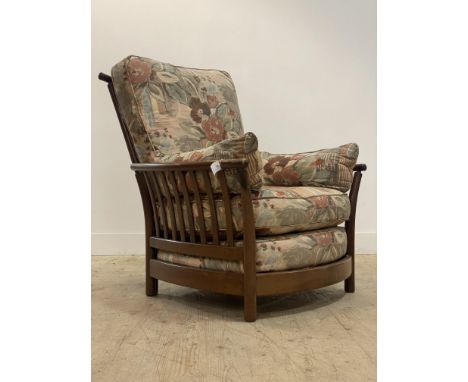 Ercol, a vintage high back armchair, with spar back and sides, squab cushions, raised on turned supports. H96cm, W90cm.