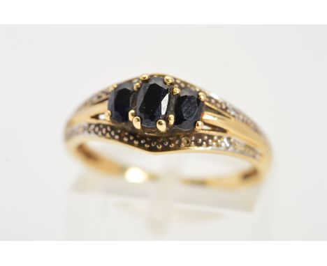 A SAPPHIRE AND DIAMOND DRESS RING, designed as a graduated line of three claw set oval sapphires within two pointed lines pav