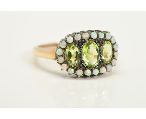 A PERIDOT AND OPAL DRESS RING, designed as three graduated oval peridots within a circular opal cabochon surround, ring size 