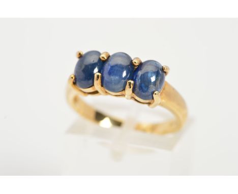 A 9CT GOLD THREE STONE SAPPHIRE CABOCHON RING, designed as three oval sapphire cabochons within claw settings, with 9ct hallm