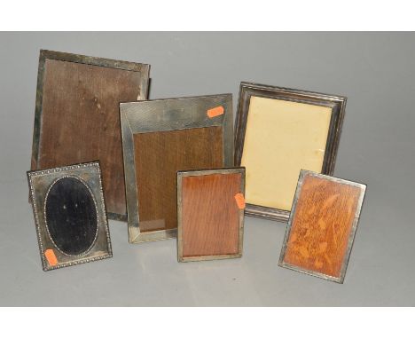 SIX EARLY 20TH CENTURY SILVER MOUNTED EASEL BACK PHOTOGRAPH FRAMES, five rectangular and one oval includes a pair, inner dime