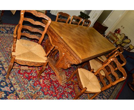 A 20TH CENTURY OAK DRAW LEAF REFECTORY TABLE, with parquetry detail to the top, carved top edge on a pair of plinths with a n