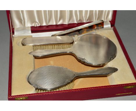 AN ELIZABETH II CASED SILVER BACKED FOUR PIECE DRESSING TABLE SET, engine turned and floral engraved, makers W G Sothers Ltd,