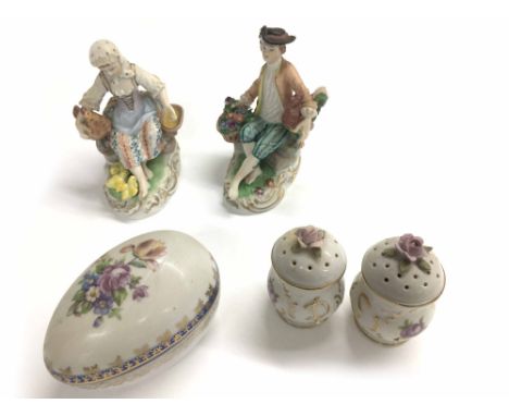 Dresden porcelain figure of a boy seated with a basket of flowers and cockerel under his arm, modelled on a naturalistic rock