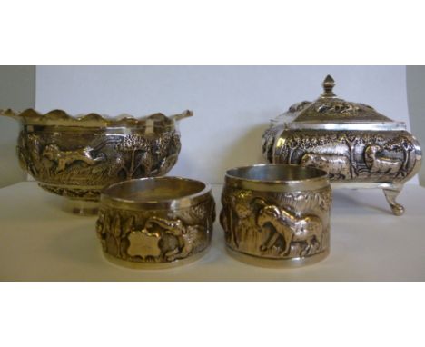Four small items of early 20thC Indian silver coloured metal, variously decorated with cast and chased wild animals and other