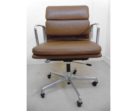 A vintage Eames for Herman Miller Soft Pad Aluminium Group chair, upholstered in cushioned brown hide, having open arms and r
