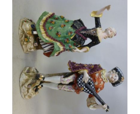 A pair of early 20thC Continental floral encrusted porcelain figures, viz. a young man wearing a waistcoat, cloak and breeche