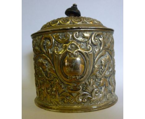 A late Victorian silver oval tea caddy, having a hinged, domed lid and an ebonised finial, decorated with embossed, cast and 