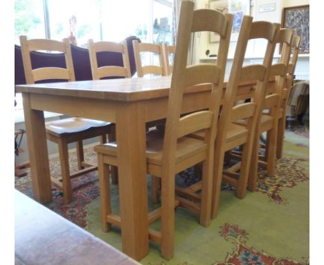 A Stewart Linford polished and dowelled light oak dining table, having a shallow frieze drawer, raised on substantial square 