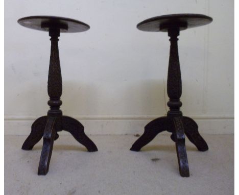 A pair of late 19thC Burmese brass inlaid hardwood wine tables, profusely carved with flowers and foliage, each having a turn