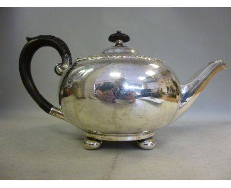 An Edwardian silver teapot of bulbous form, having gadrooned ornament, a swept spout with a shell cast mount, a C-scrolled, f