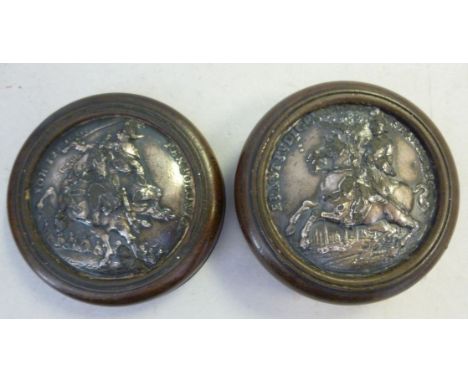 A 19thC turned wooden snuff box, the two parts on a threaded connection, mounted with cast white metal medallion mounts