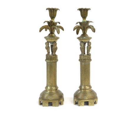 A Pair of Brass Candlesticks, 19th century, with leaf cast sockets and drip pans on three owl supports and fluted columns, th