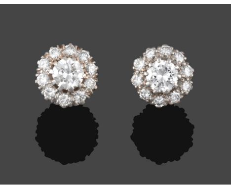 A Pair of Diamond Cluster Earrings, a raised central round brilliant cut diamond within a border of smaller round brilliant c