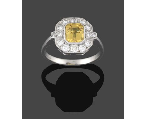 An Art Deco Style Yellow Sapphire and Diamond Ring, the central emerald-cut yellow sapphire within a border of round brillian