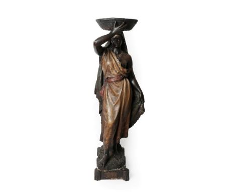 A Goldscheider Painted Terracotta Figure of a Nubian Girl, circa 1900, standing wearing loose robes, a basket on her head, on