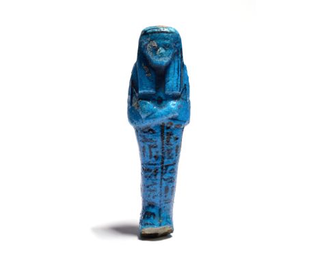 An Egyptian turquoise faience shabti Third Intermediate Period, circa 1080 - 945 BC with tripartite wig and crossed arms, wit
