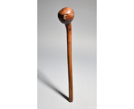 A Hehe knobkerrie Tanzania with a carved head having a short beard, the end of the shaft pierced for attachment, 50cm long.