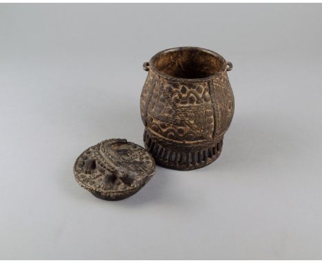 An Ashanti gold dust box kuduo Ghana cast brass with a bulbous body decorated circles and lines and with two loops under the 