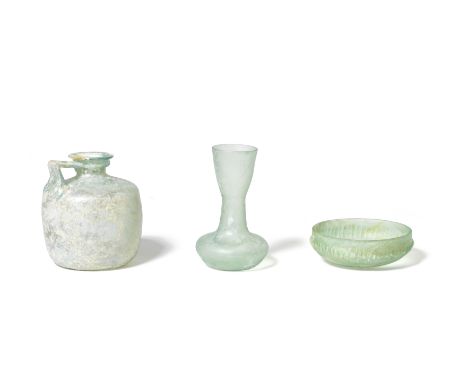  Three Roman green glass vessels Circa 1st-4th Century A.D.Comprising a pillar mould-cast bowl, the interior with double whee