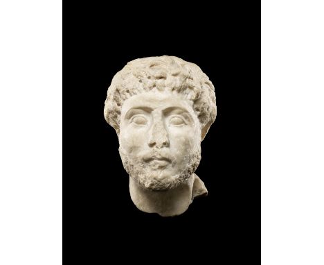  A Roman marble male portrait head Circa late 2nd Century A.D.With drilled thick curly hair covering the tops of the ears, th