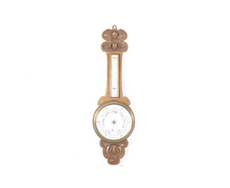 A Victorian banjo aneroid barometer. The Rossiter & Sons dial mounted in a carved oak case with a thermometer positioned on t