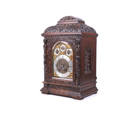 A Winterhalder & Hofmeier Germany bracket mantel clock. Heavily carved oak case with foliage and 'Green Man' over caryatids, 