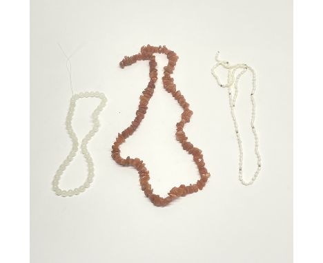 A carnelian necklace with a white jade necklace and a freshwater pearl necklace.