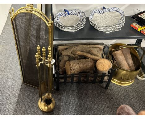 A cast iron fire grate with logs, brass log bucket companion set and fire screen.