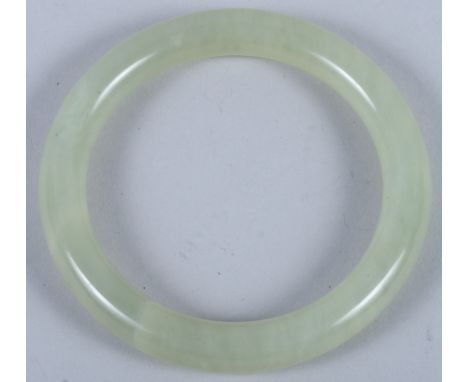 A celadon green jade bangle, 3 1/2" wide