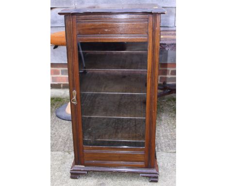 An Edwardian mahogany music cabinet enclosed glazed door, on splay bracket supports, 19" wide