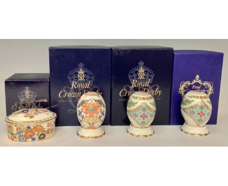 A pair of Royal Crown Derby Russia pattern "World Eggs" on stands, gold buttons, 8cm high, printed marks, each boxed; a Japan