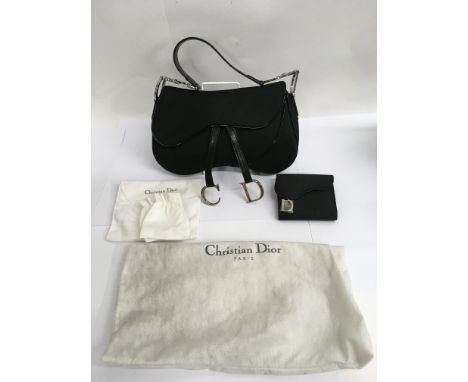 A Christian Dior designer black 'saddlebag' handbag and matching purse with dustbags, in unused condition