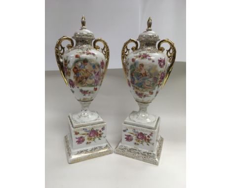 A pair of ceramic lidded vases with transfer print decoration of a young couple surrounded by floral sprays, height 41.5cm.