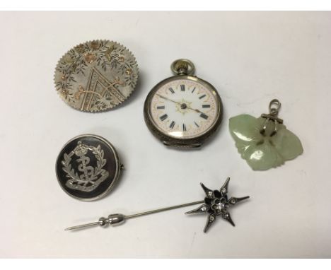 A small fob watch, silver brooch, stick pin and jade pendant.