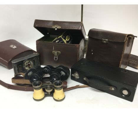 A collection of camera equipment Carl Zeiss binoculars and other cameras.