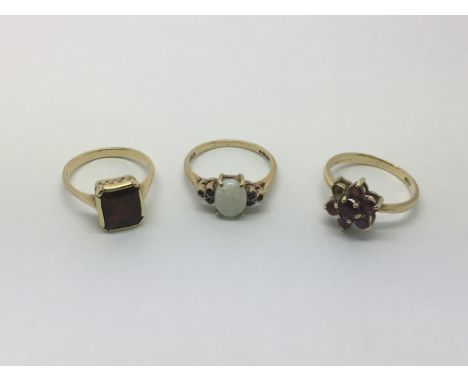 Three gold rings, an opal ring, a garnet ring and one set with rubies. Total approx weight 6.3g, sizes between K and M.