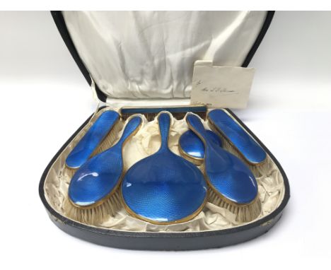 A fitted case of 1920's dressing table brush and mirror set in blue enamel.