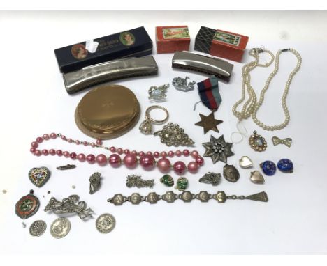 A collection of oddments, dress jewellery, silver medals, cigarette cards, harmonica etc.