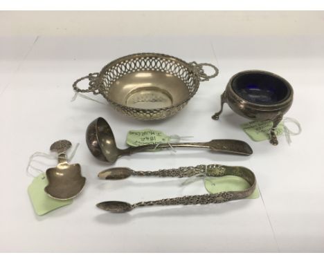 A collection of silver to include a dish, caddy spoon, sugar tongs etc.